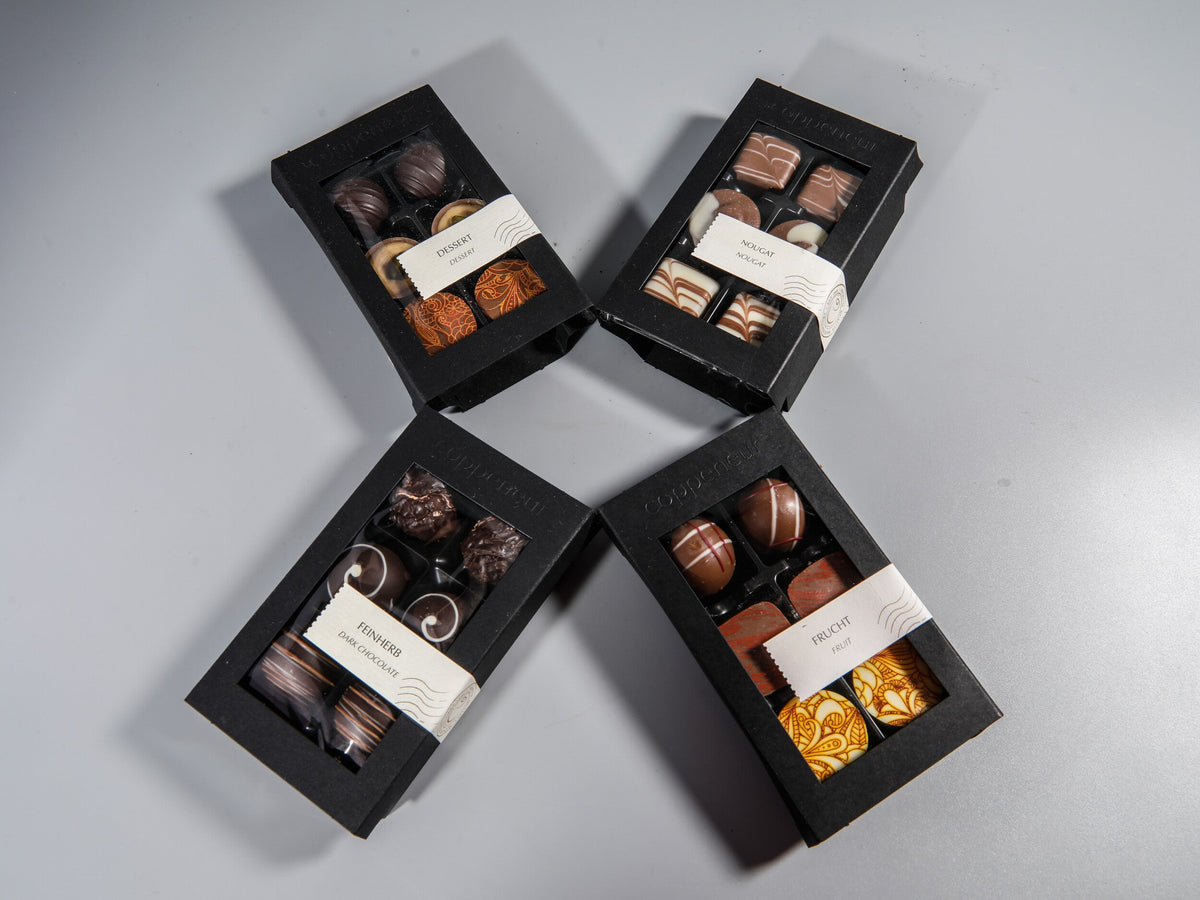 Vier Geschenkschachteln mit ausgewählten Pralinen