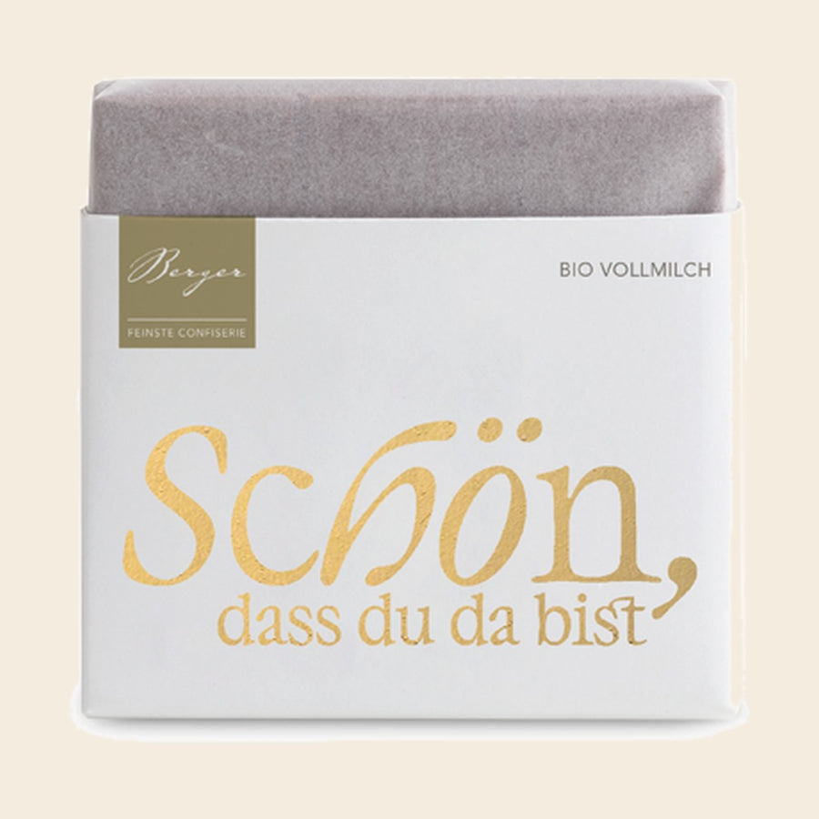 Thementafel Bio Vollmilch "Schön, dass du da bist" – Tafelschokolade von Confiserie Berger, 40 g, freigestellt vor cremefarbenem Hintergrund