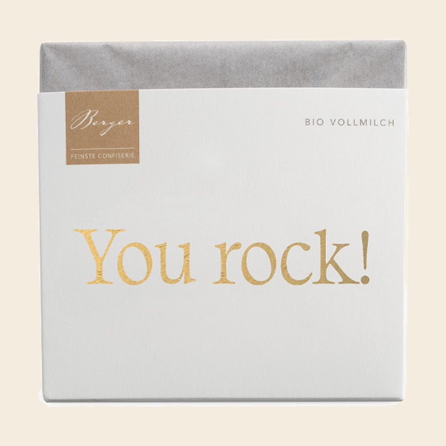 Thementafel Bio Vollmilch "You Rock" – Tafelschokolade von Confiserie Berger, 70 g, freigestellt vor cremefarbenem Hintergrund