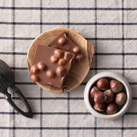 Bio Vollmilchschokolade mit gerösteten Haselnüssen – Schokolade von Confiserie Berger, 100 g, angerichtet