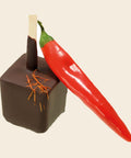 Trinkschokolade Chili – Trinkschokolade am Stiel von Art of Chocolate, 30 g, freigestellt vor cremefarbenem Hintergrund