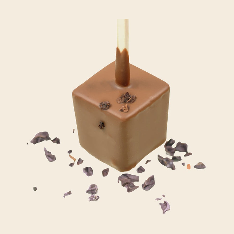 Trinkschokolade Vollmilch – Trinkschokolade am Stiel von Art of Chocolate, 30 g, freigestellt vor cremefarbenem Hintergrund