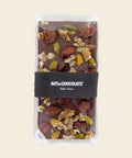 Tafel Vollmilchschokolade mit karamellisierten Mandeln, Walnüssen & Pistazien – Tafelschokolade von Art of Chocolate, 150 g, freigestellt vor cremefarbenem Hintergrund