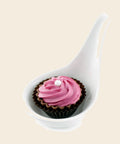 Taste Löffel mit Cupcake: Himbeer – Praline von Art of Chocolate, 18 g, freigestellt vor cremefarbenem Hintergrund