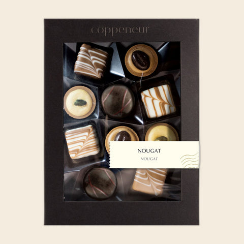 10er Sélection Nougat Pralinés von Coppeneur – Pralinenschachtel freigestellt auf cremefarbenem Hintergrund