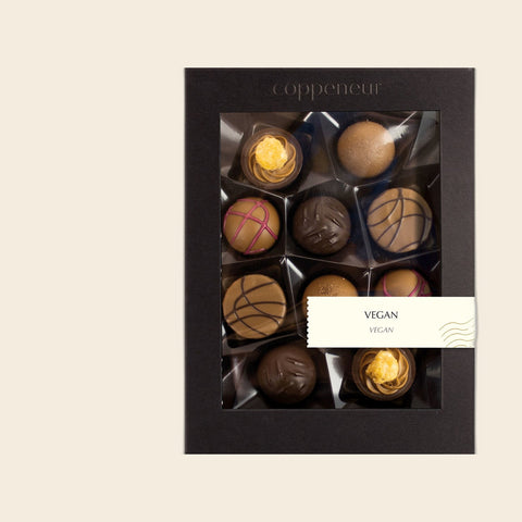 10er Sélection Vegane Pralinés von Coppeneur – Pralinenschachtel freigestellt auf cremefarbenem Hintergrund