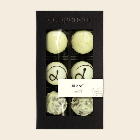 6er Sélection Blanc von Coppeneur – Pralinenschachtel freigestellt auf cremefarbenem Hintergrund