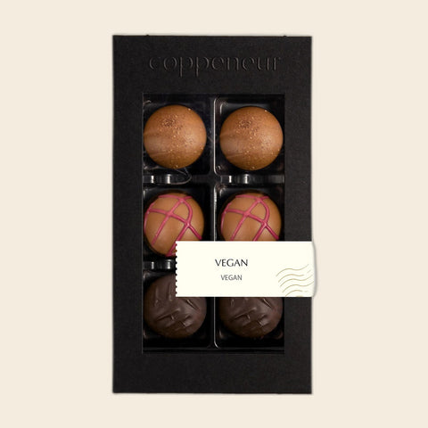 6er Sélection Vegan von Coppeneur – Pralinenschachtel freigestellt auf cremefarbenem Hintergrund