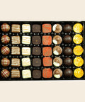 Grande Sélection o. Alk. von Coppeneur – 40 Truffes und Pralinés im Tray auf cremefarbenem Hintergrund