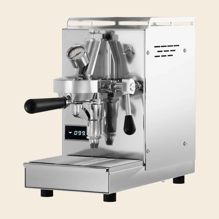 Elba Mini Espressomaschine in Edelstahl mit schwarzen Holzdetails, freigestellt auf cremefarbenem Hintergrund